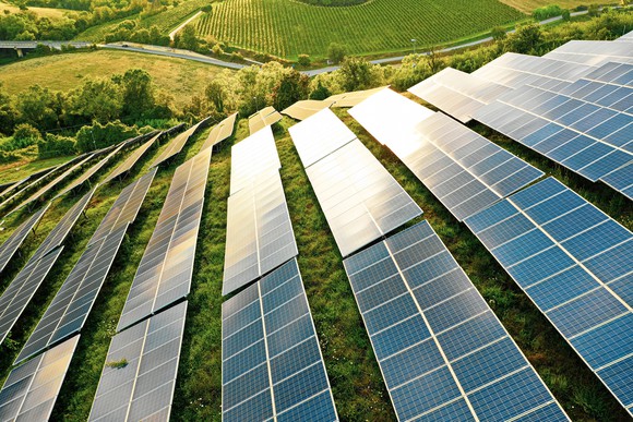 Large solar farm on a large grassy hill. 