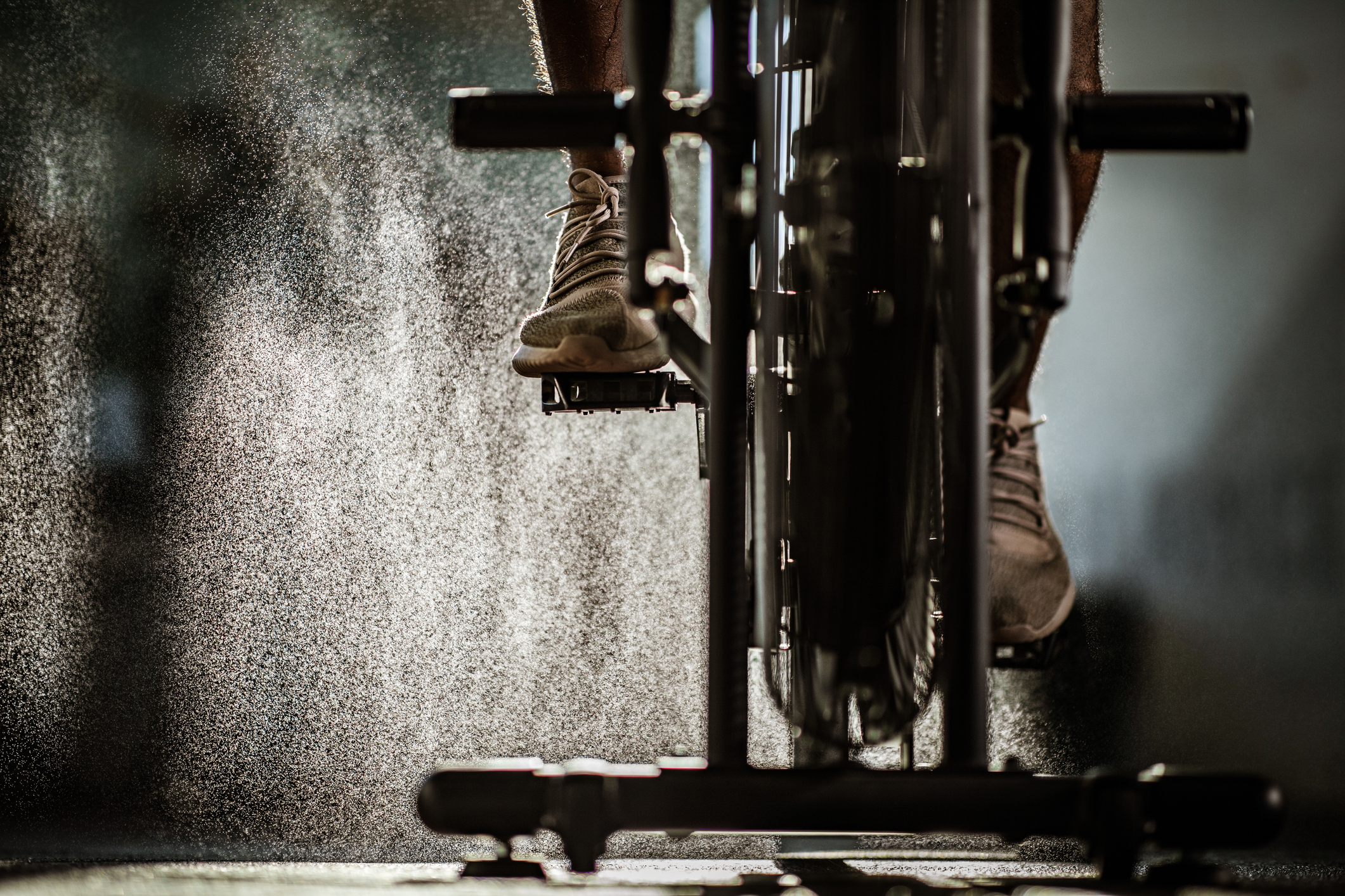 The bottom half of an exercise bike in use.