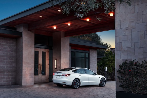 Tesla parked outside of a building by twilight.