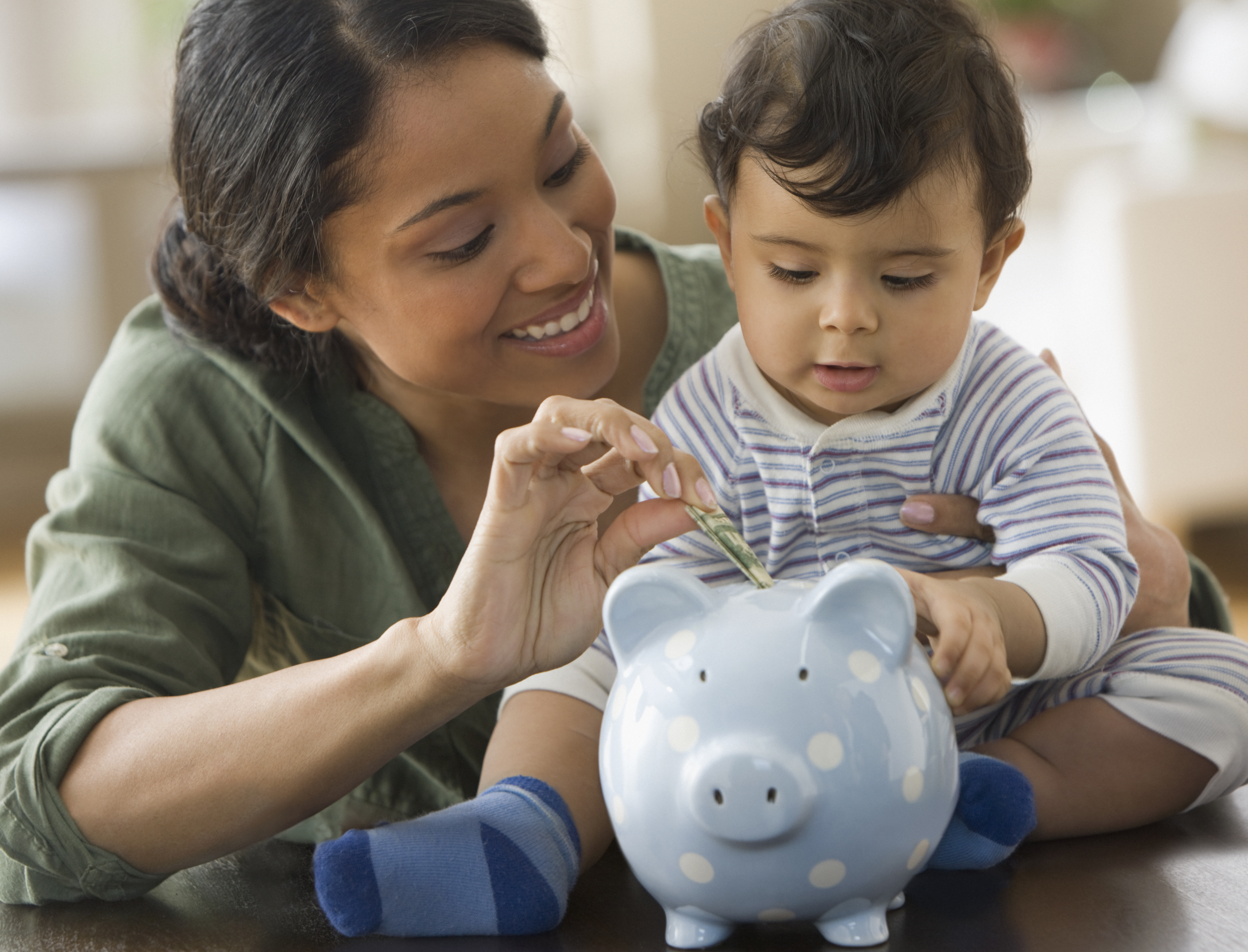 Mom and son saving money in piggy bank.