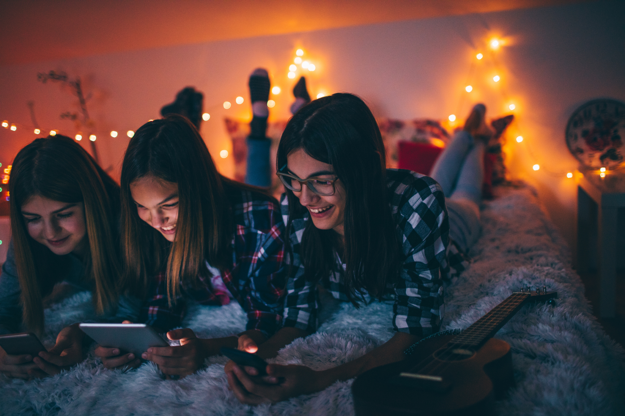 Three younger individuals using their electronic devices.