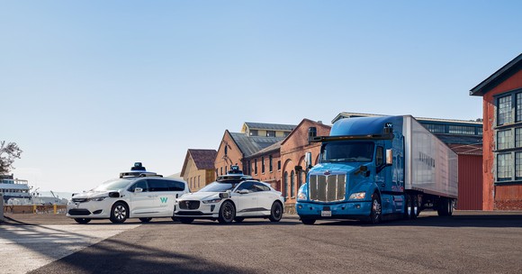 Waymo vehicles lined up in a parking lot. 