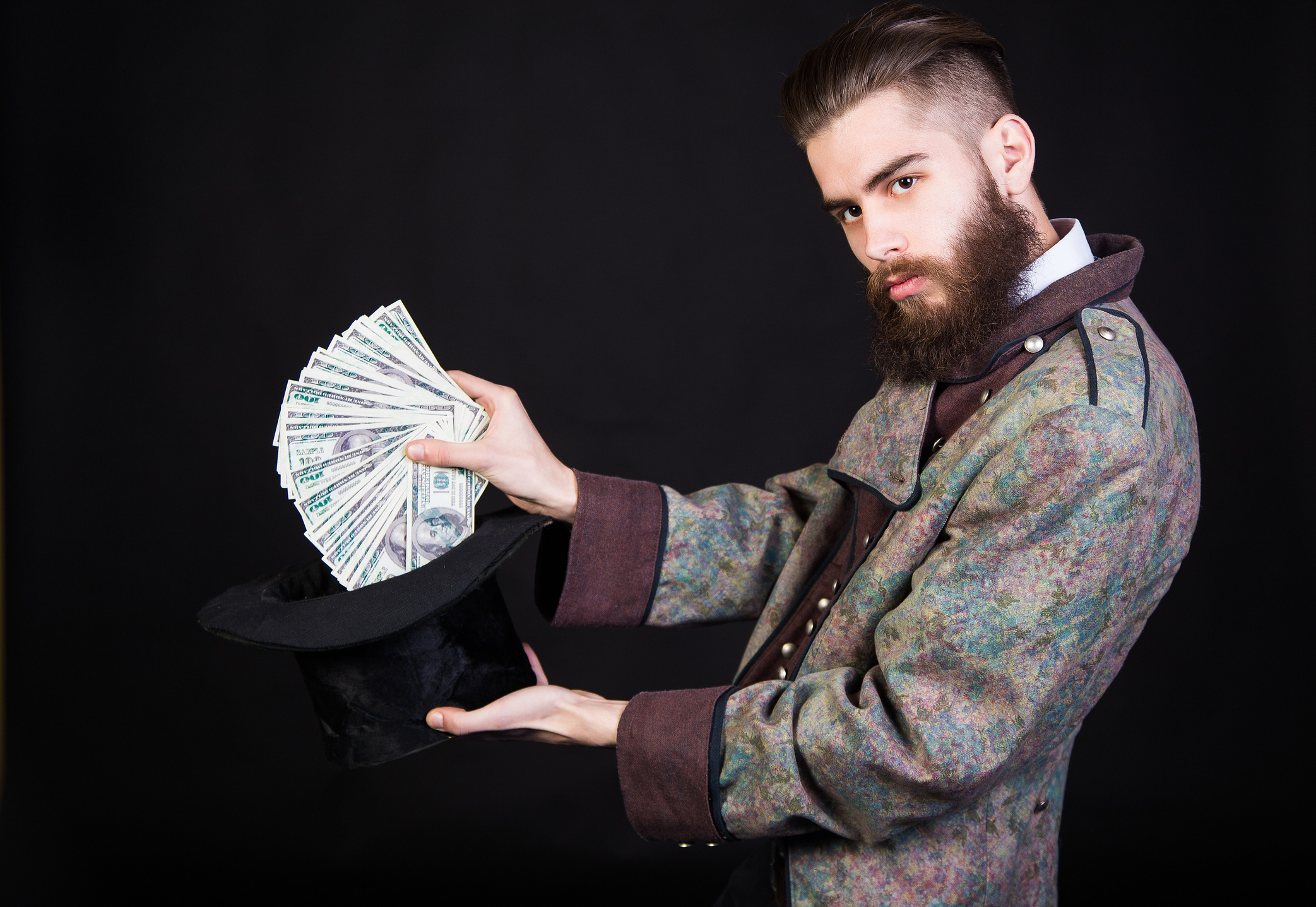 Magician pulling a bunch of cash from a hat.