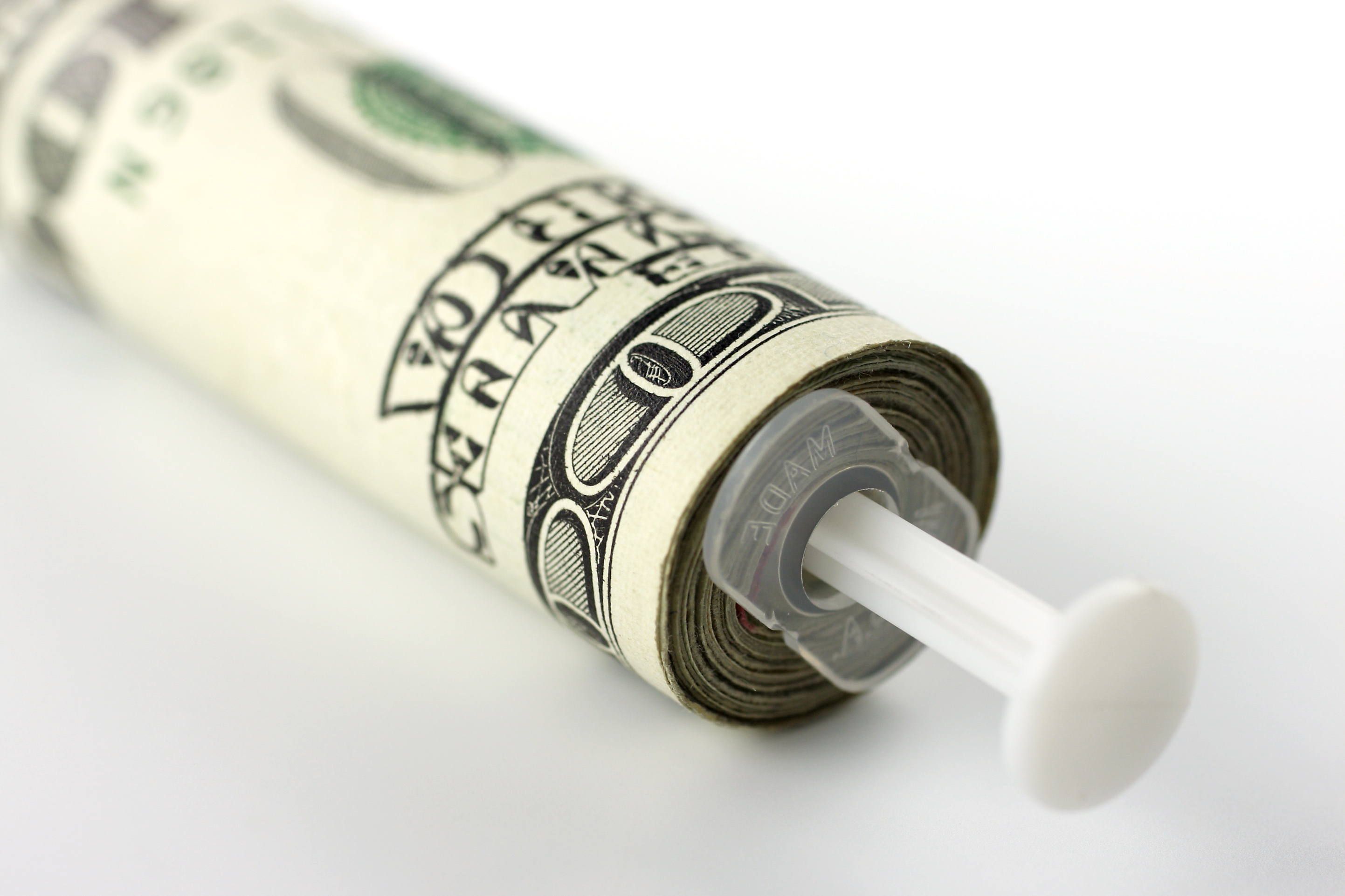 A syringe with U.S. cash rolled around it.