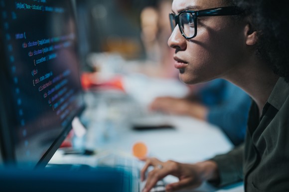 A person concentrating on data on a computer screen.