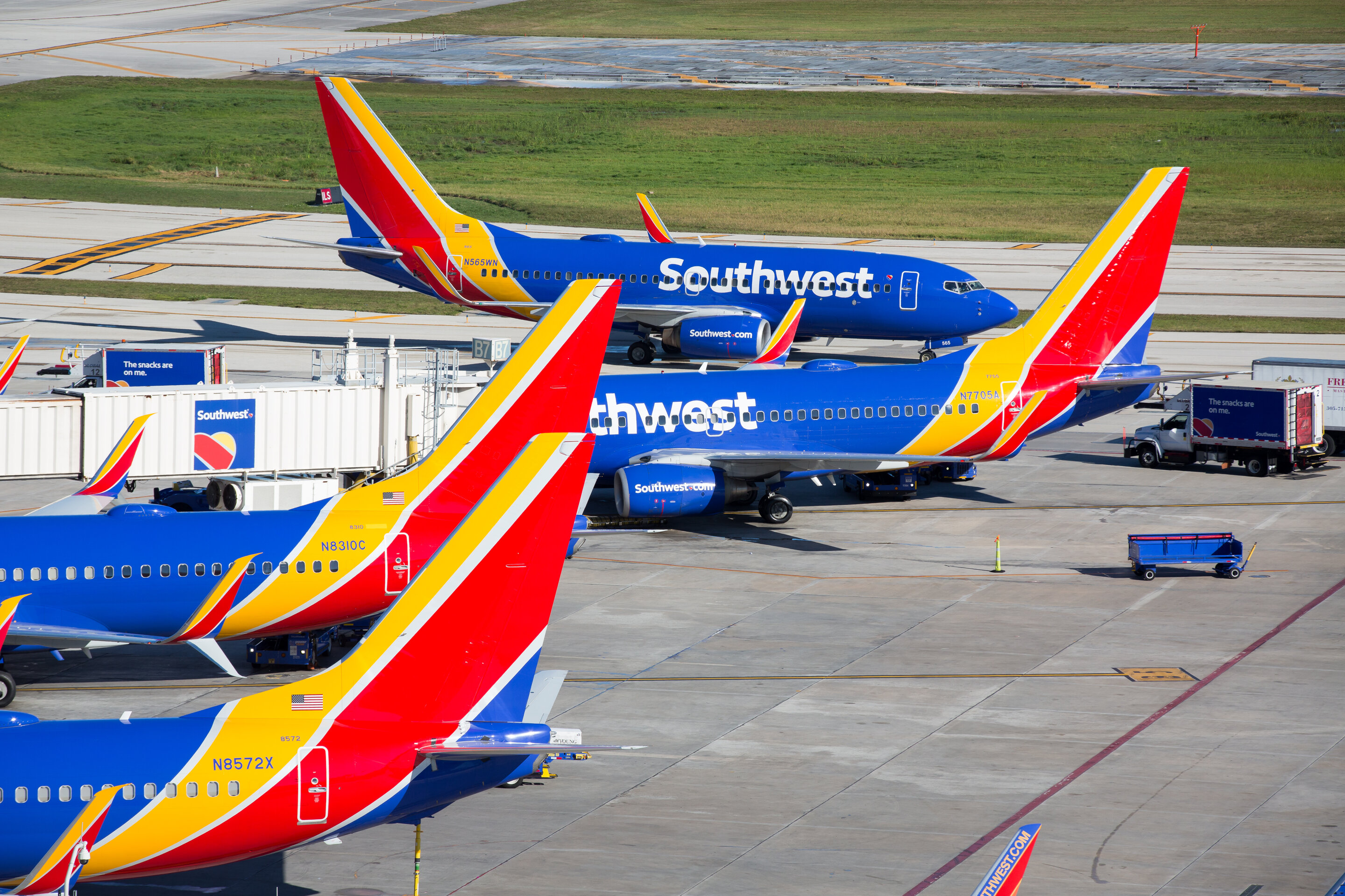Several Southwest Airlines planes in an airport gate area.
