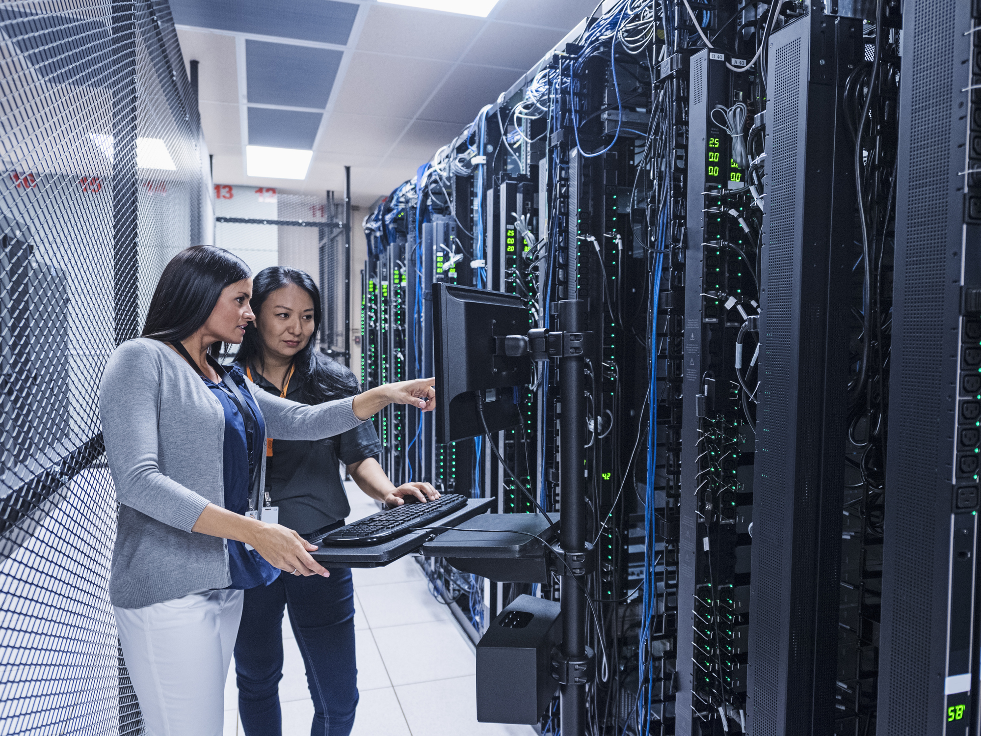 Two engineers inspecting computer servers.