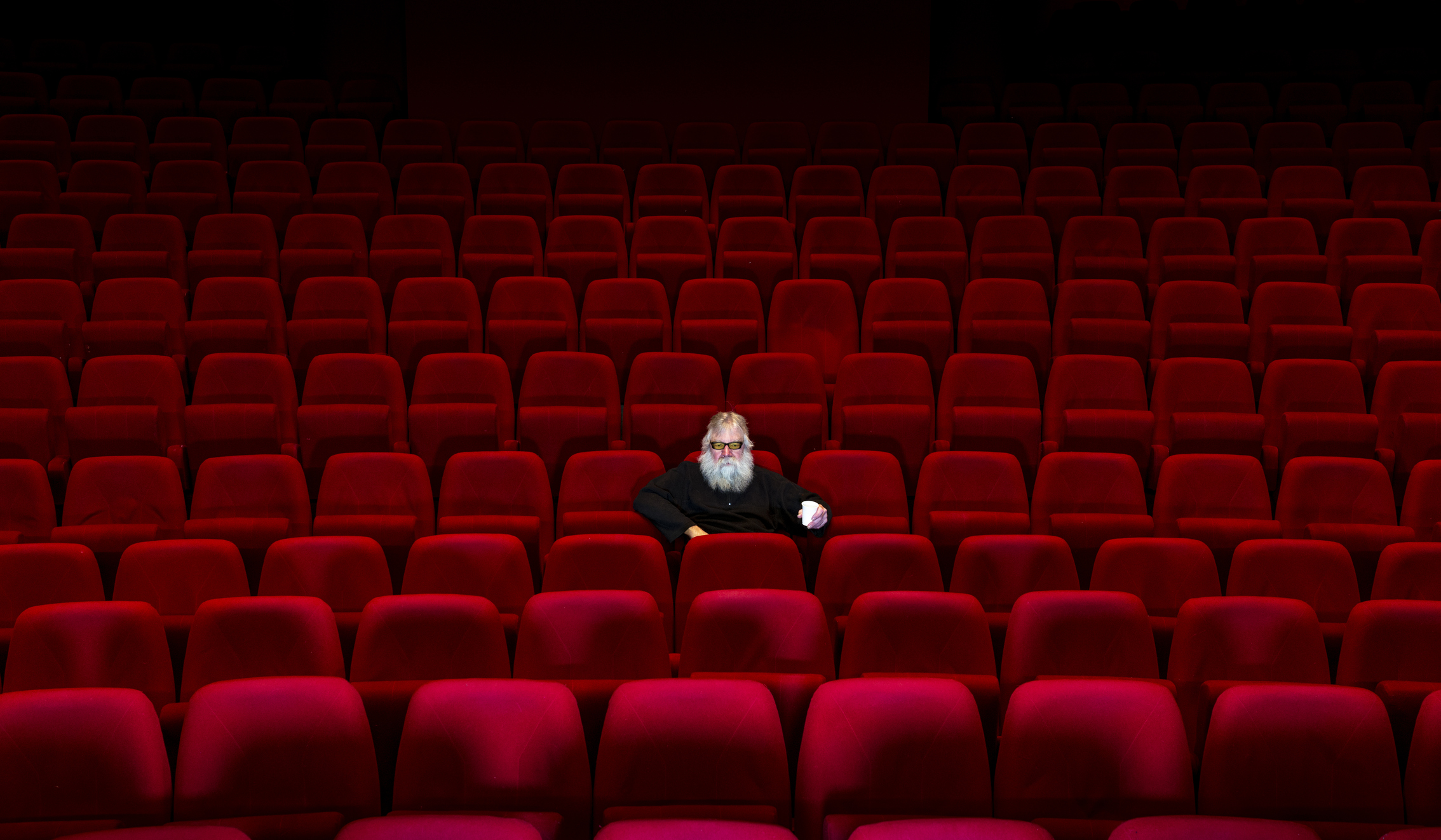 A lone person sitting in an empty movie theater.