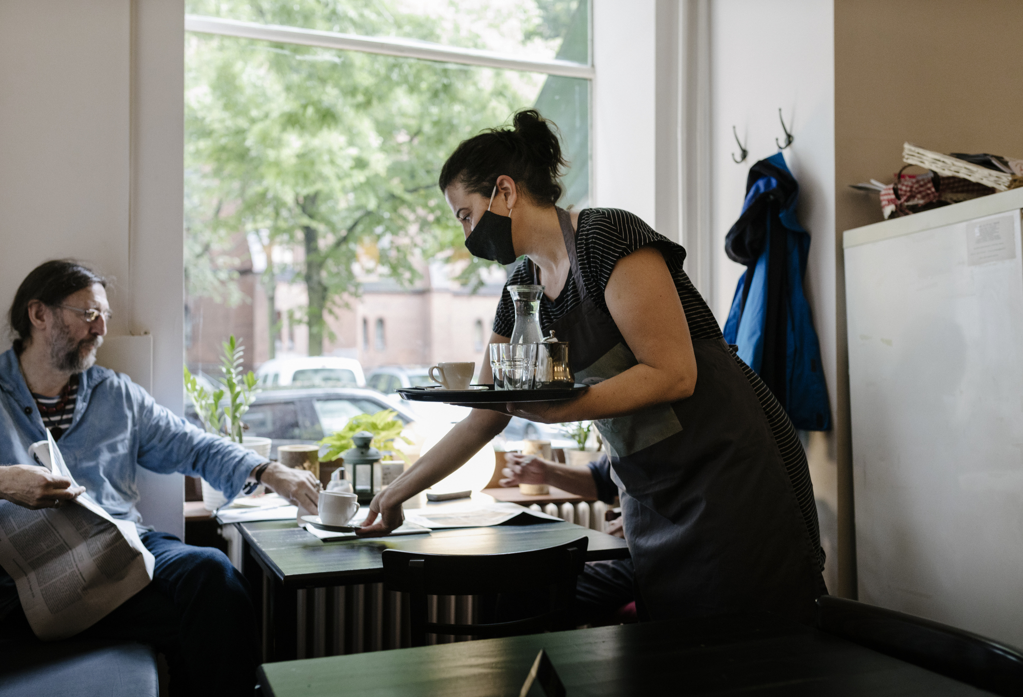 A server delivers coffee to customer at a restaurant.