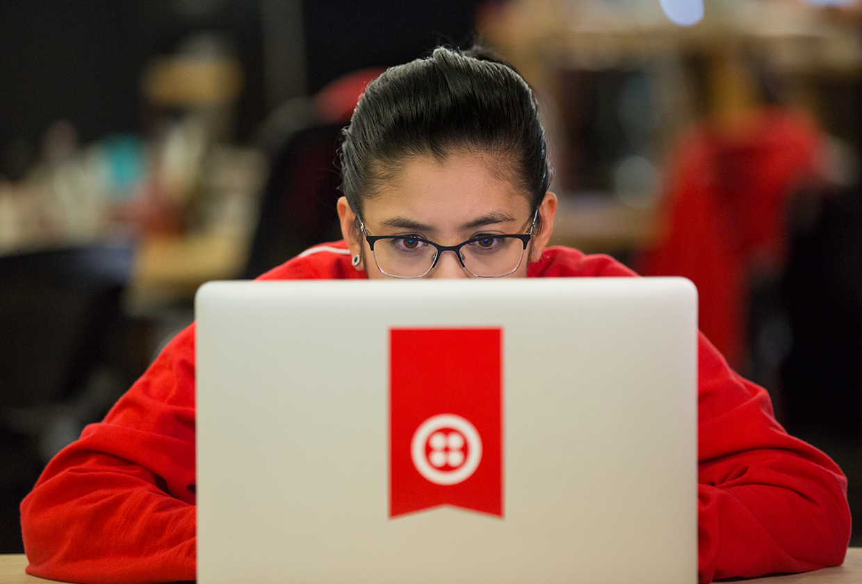 Programmer using a laptop with a Twilio logo.