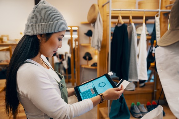 Retail shop clerk taking a card payment on a tablet.