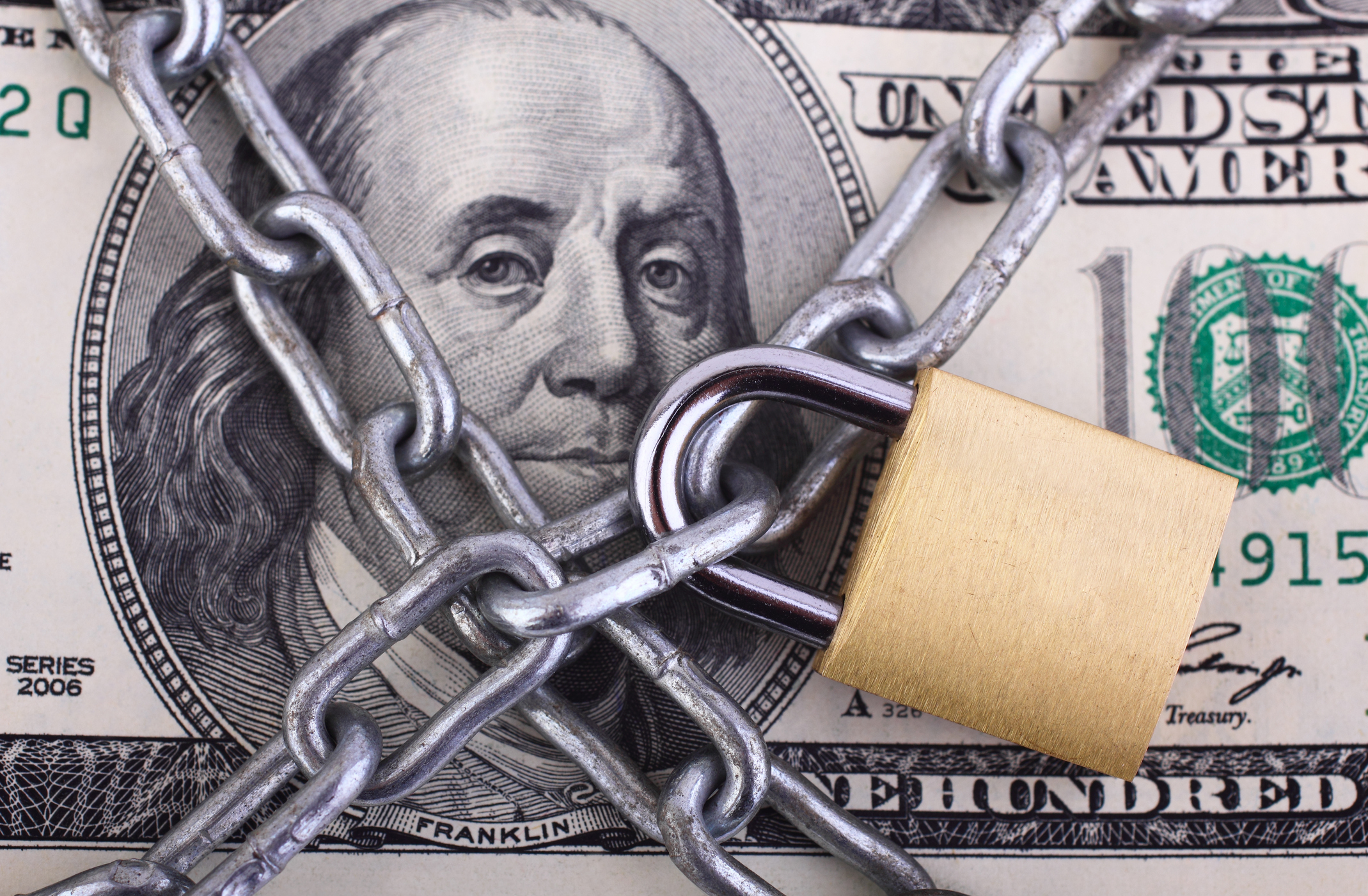 Padlock and chain on $100 bill.