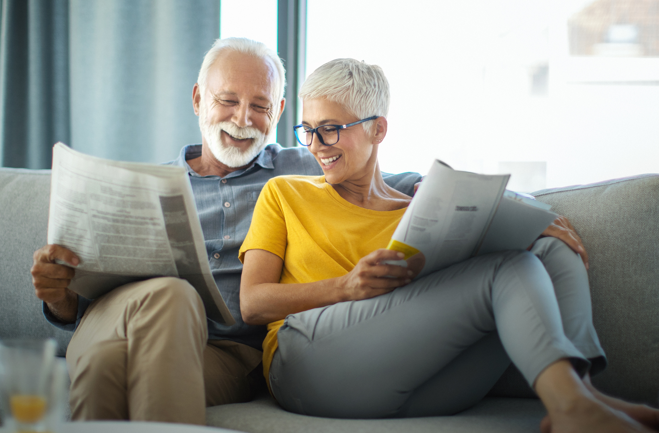 Two people on couch holding reading materials