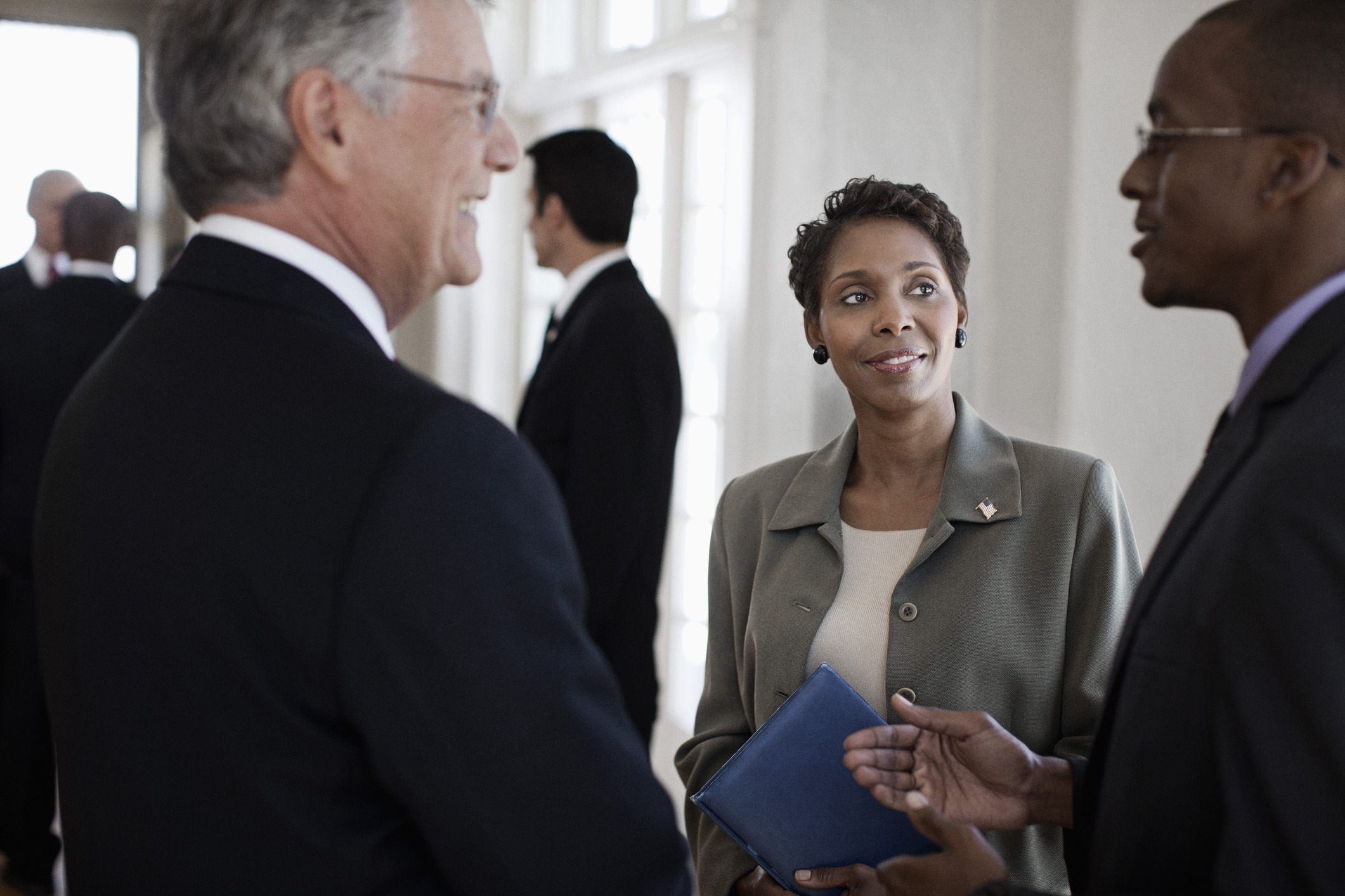 A group of business people talking inside a building.