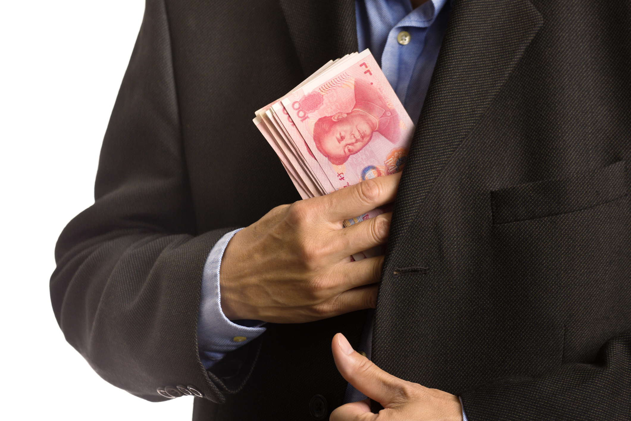 Closeup on businessman putting wad of yuan cash into suit pocket.