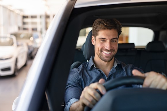 Happy person driving an electric vehicle.