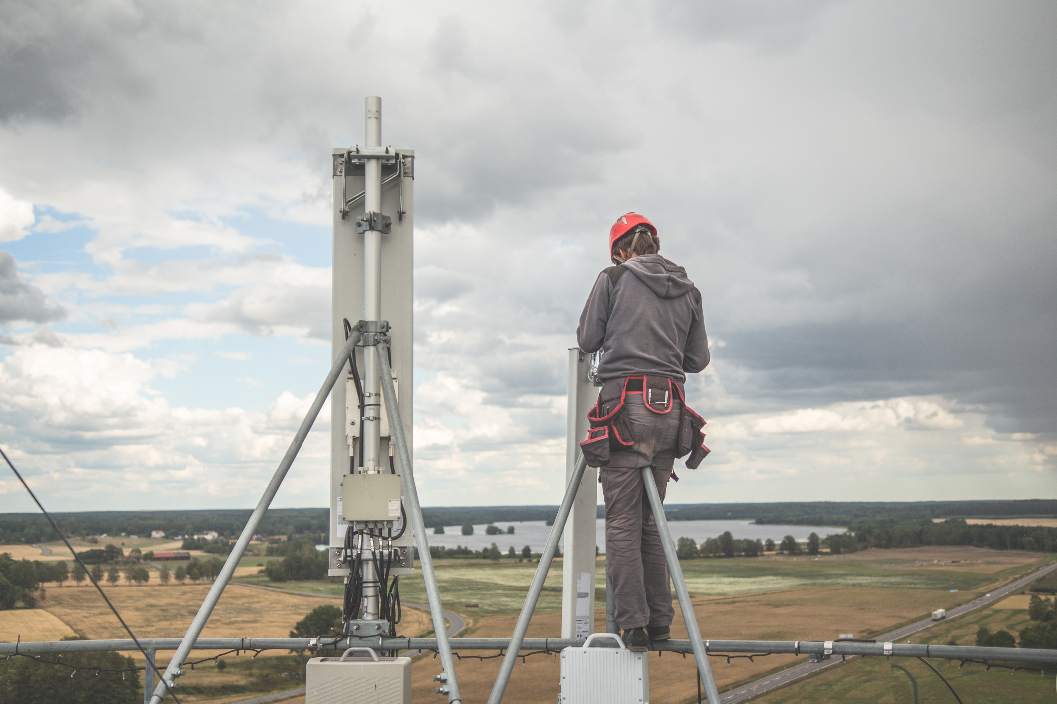 A man standing on a tall pole.