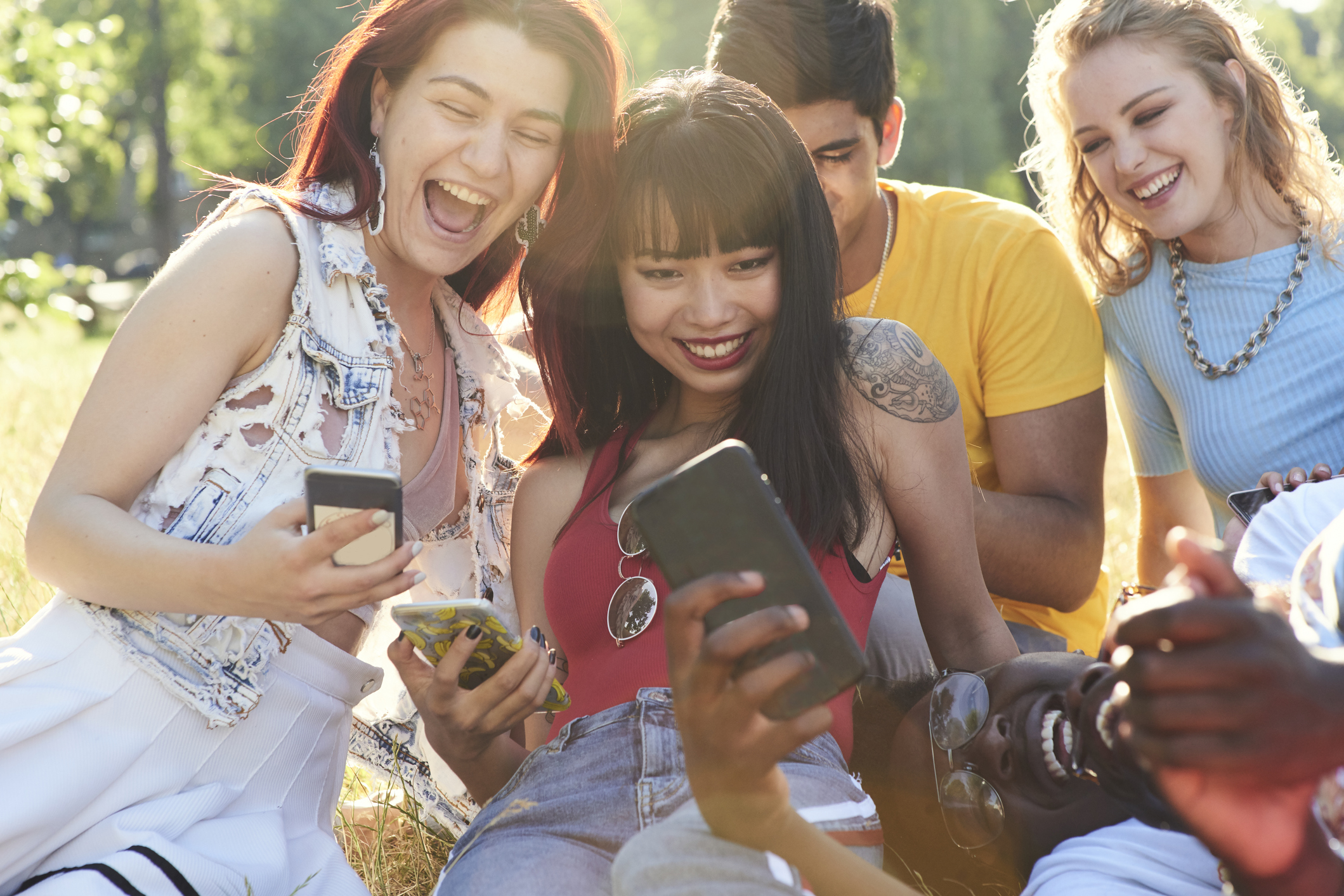 Group of friends laughing while on their phones