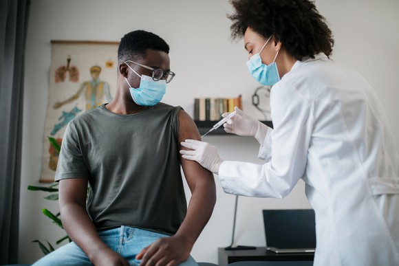A healthcare professional giving a shot to a person.