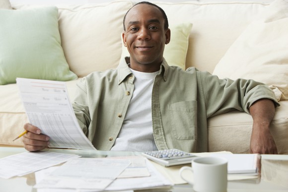 A person smiling and reviewing their finances.