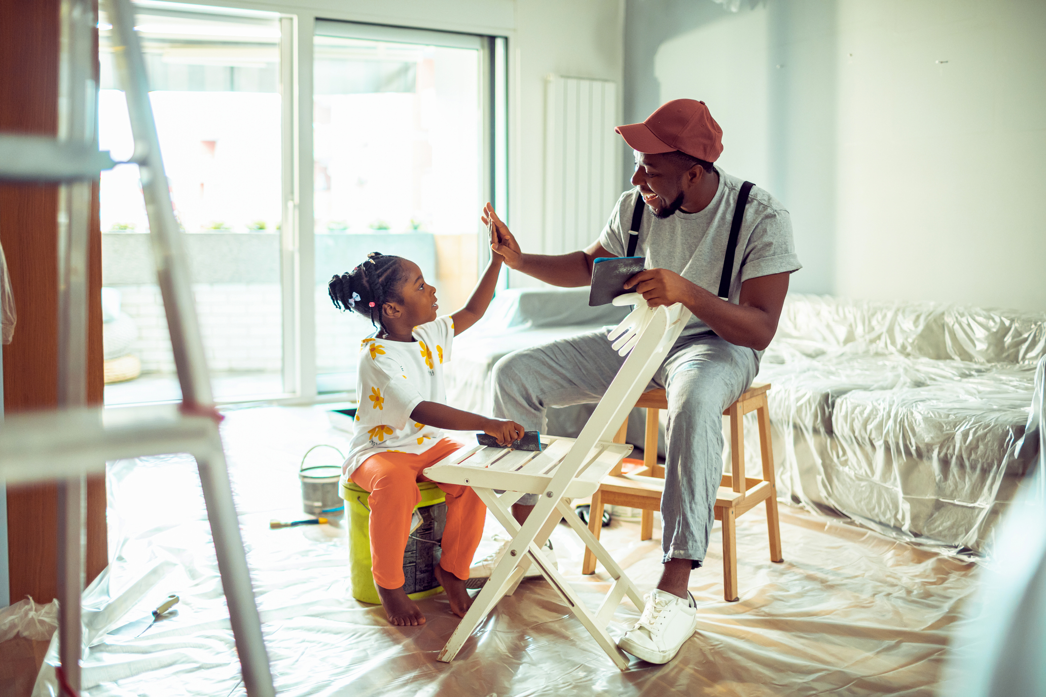 Parent and child high-fiving while working on home renovation project.