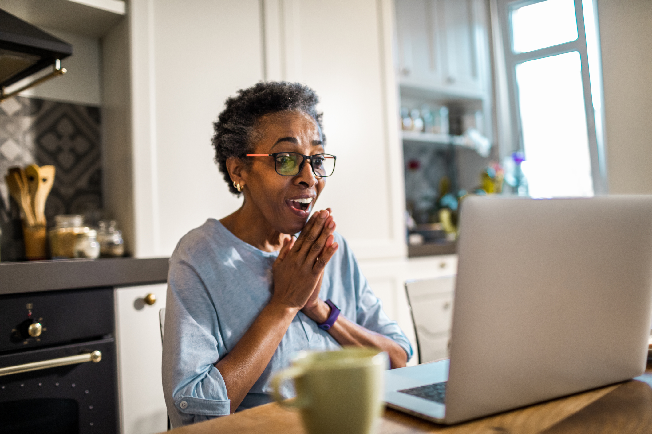 A reaction of joy as a computer user stares at a laptop.