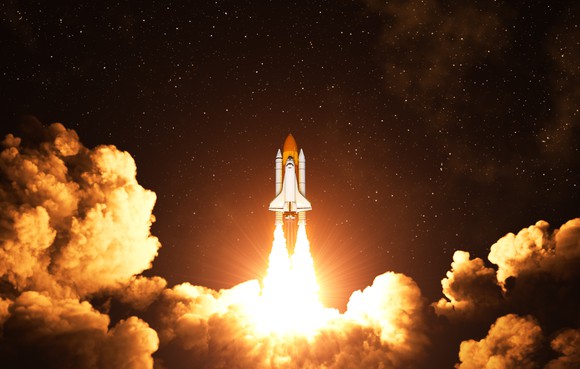 Space shuttle blasting off into a black sky