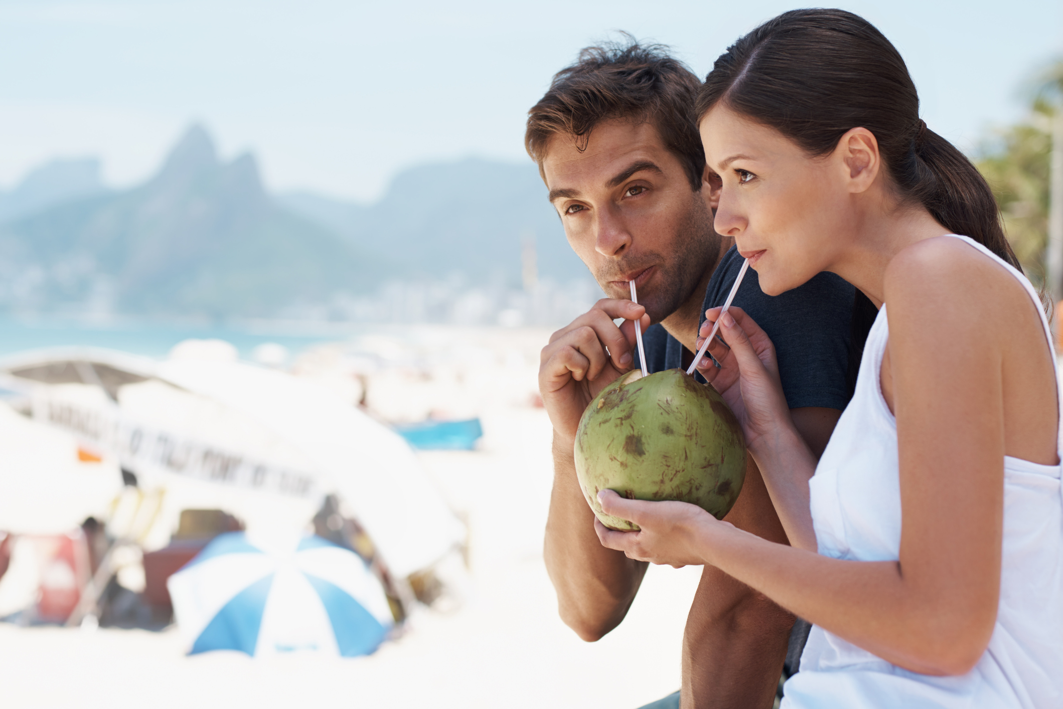Couple sipping coconut water out of a fresh coconut in a hotel