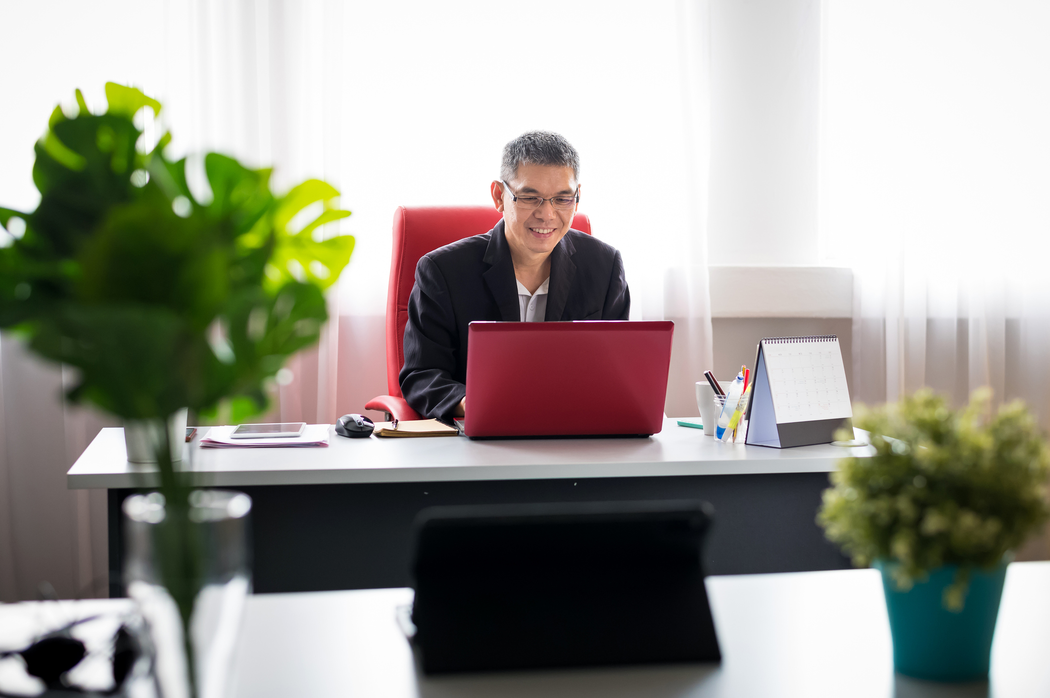 A person in an office looking at a laptop.