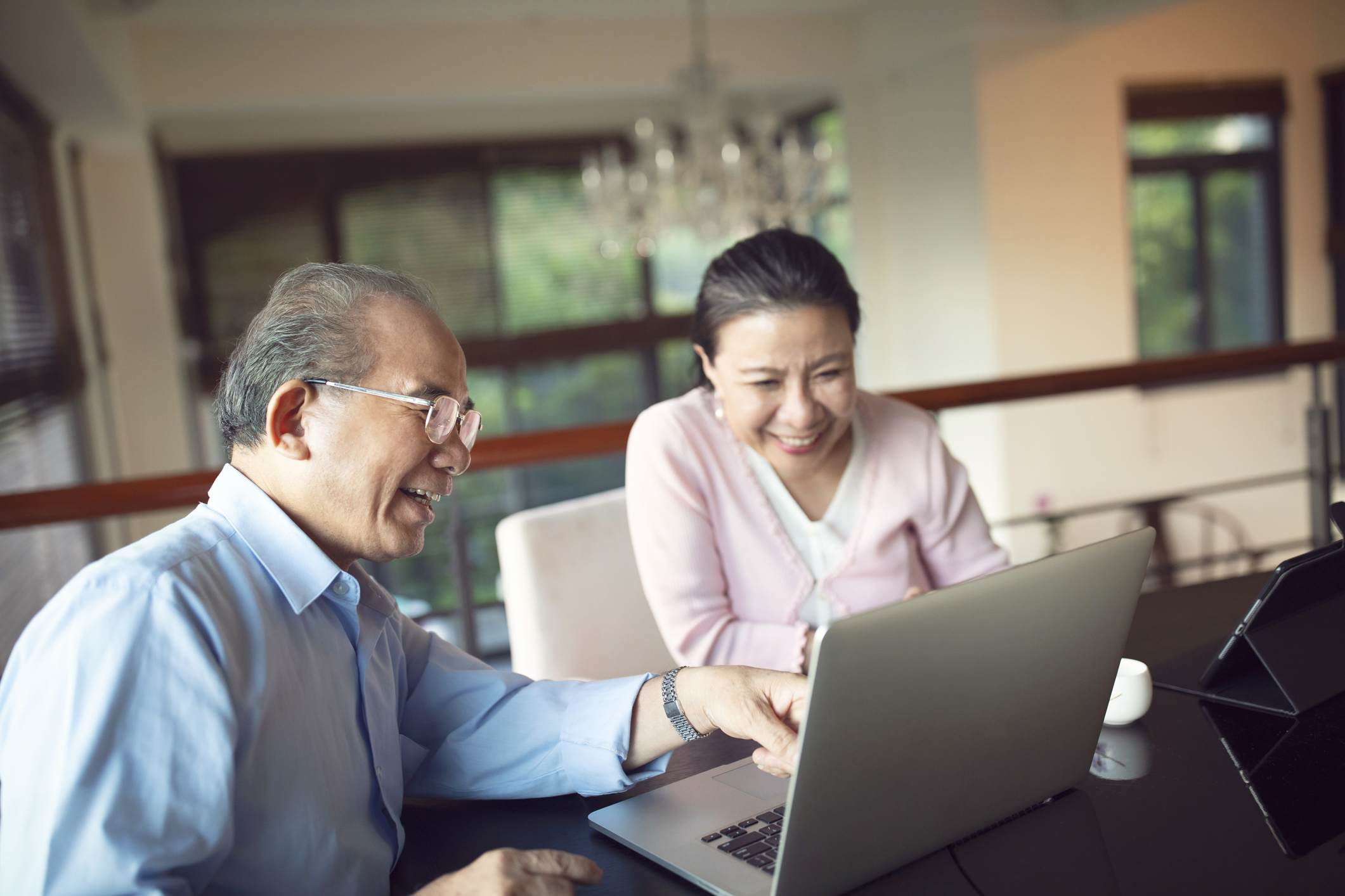 Two smiling people looking at a laptop.