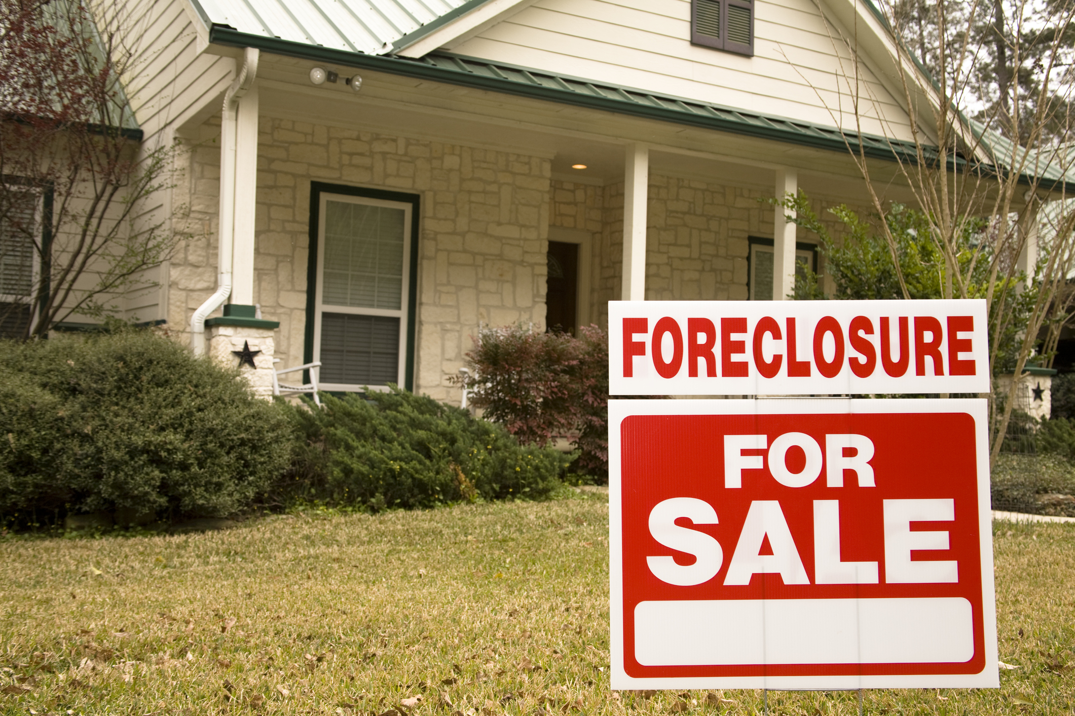 house with foreclosure sale sign