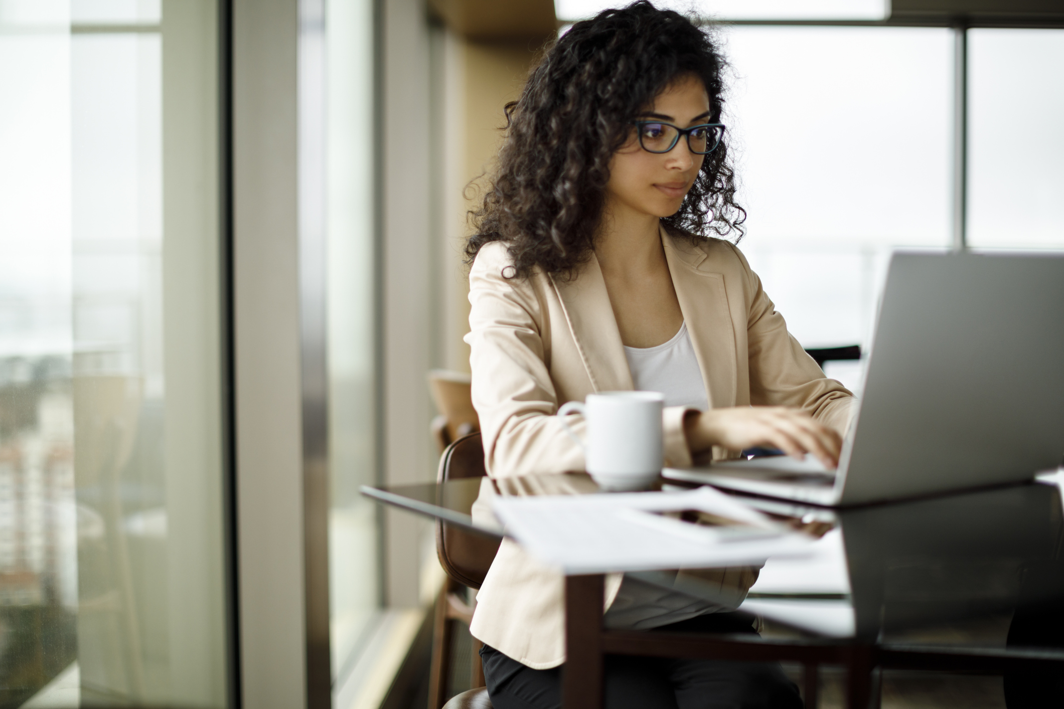 Investor sitting at her desk and engaged with her computer.