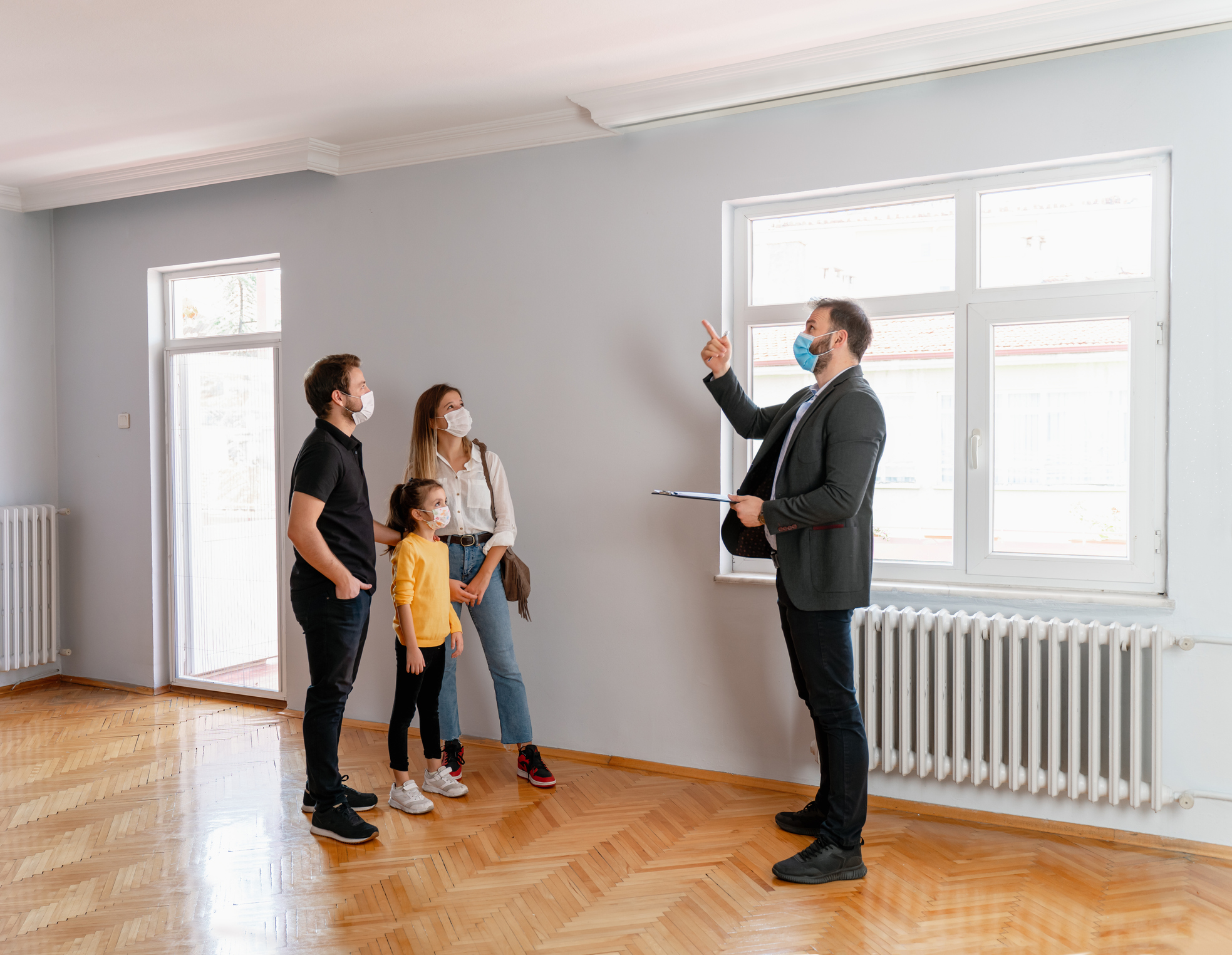 a family looks at the interior of a house with a real estate agent