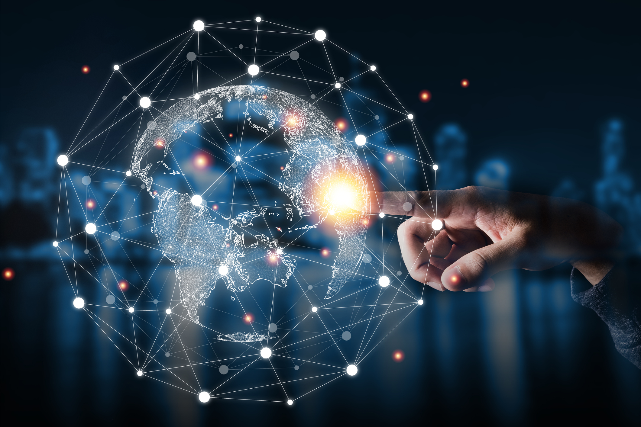 A hand touches a point in west Africa that glows bright on an integrated and connected globe.