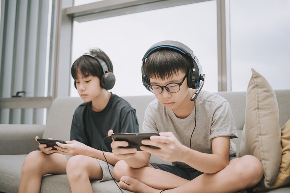 Two people playing games on their phone.