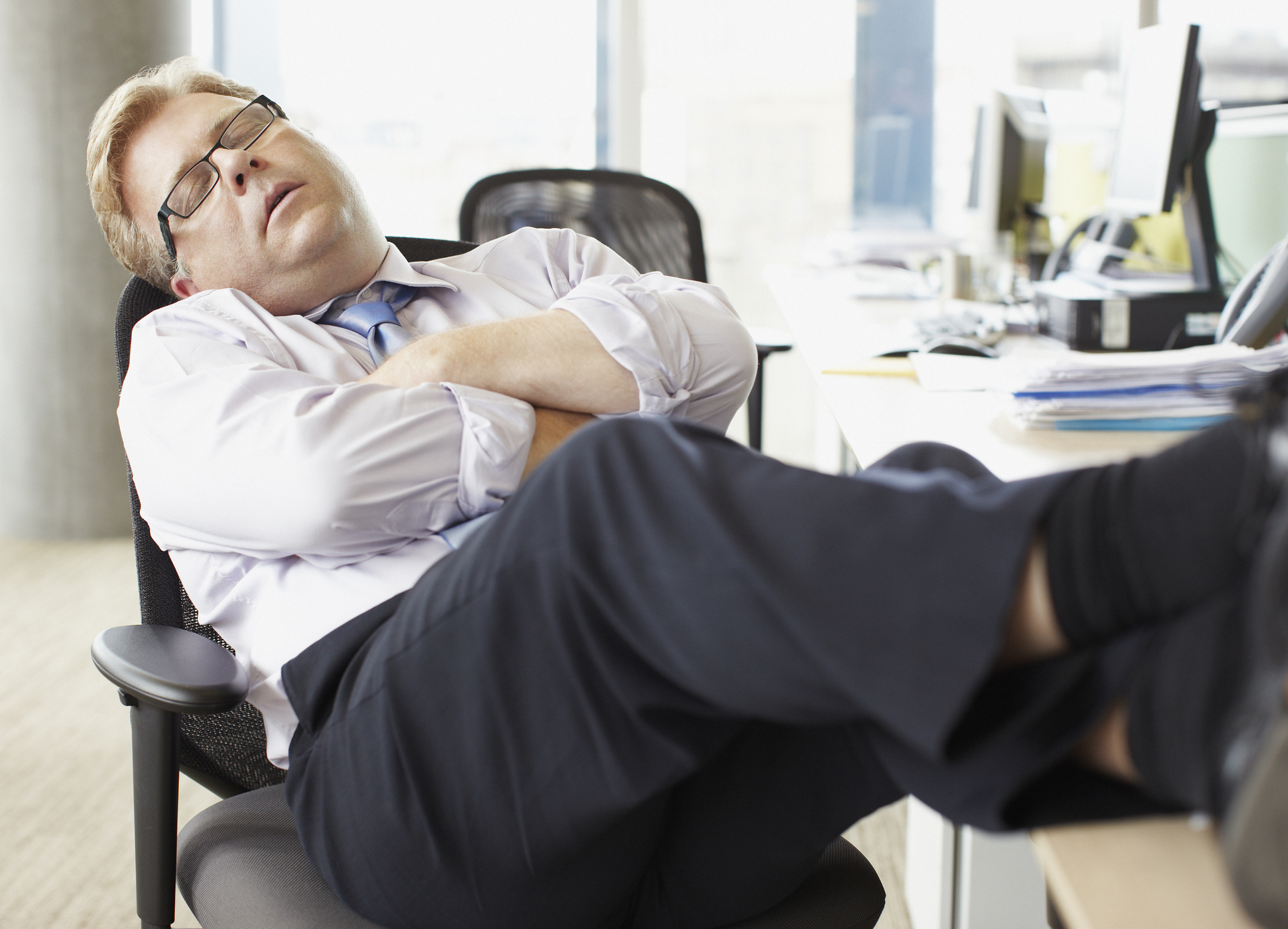 Wall Street worker sleeping at his desk.