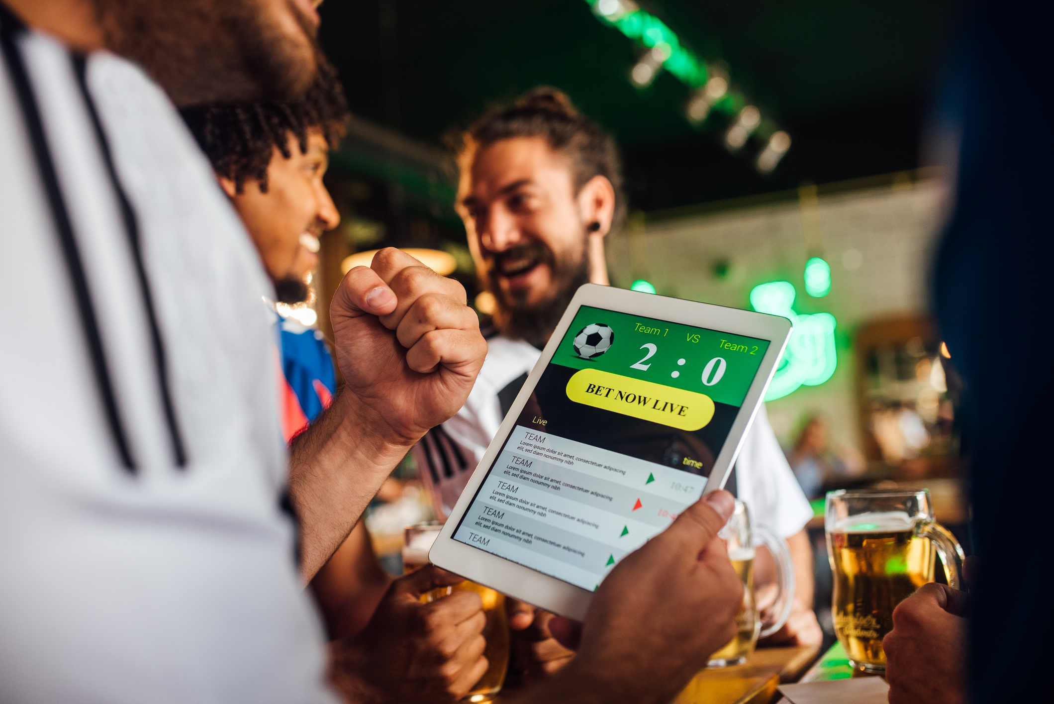 A person using a tablet to make an online sports wager on a soccer match.