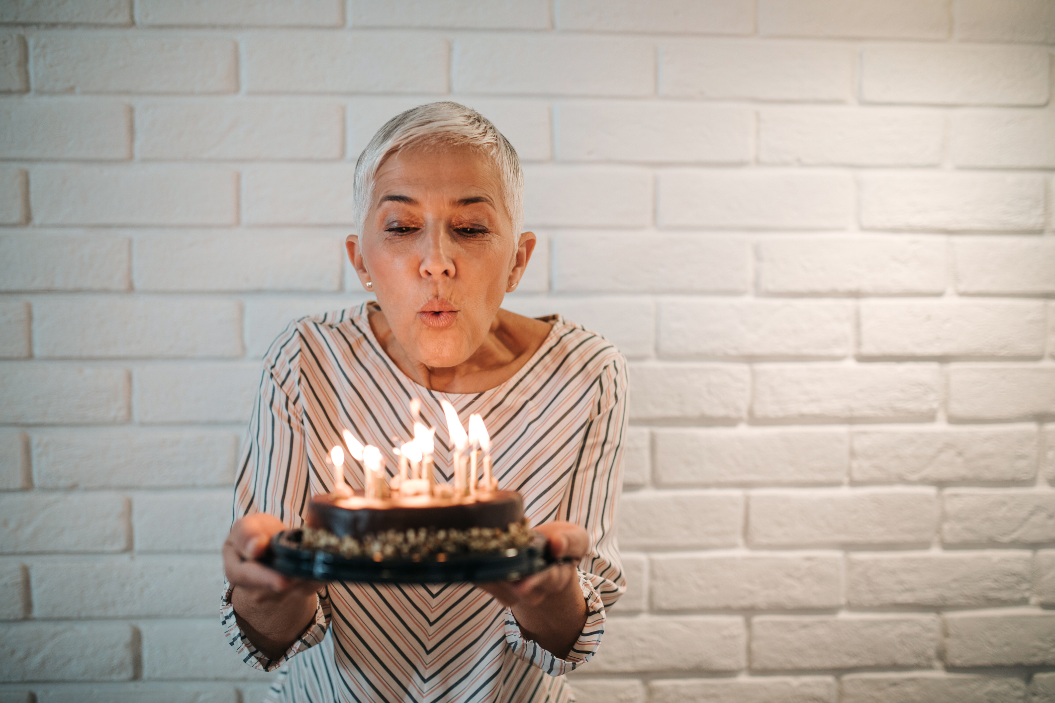 A person blows out the candles on a birthday cake.
