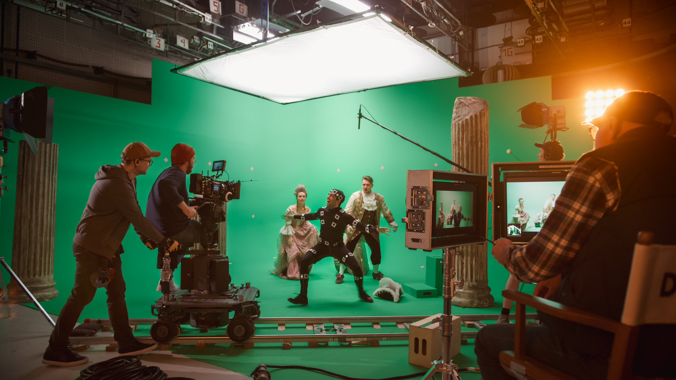 Filming on the green-screen movie set of a period piece while the director looks on.