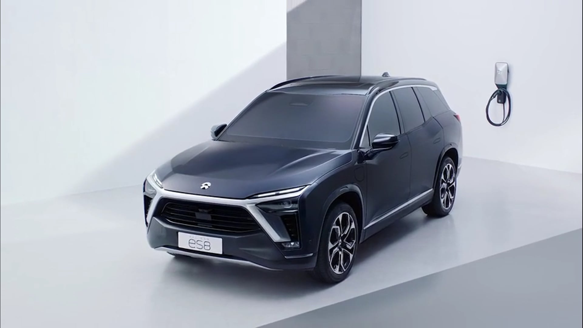 black Nio ES8 in front of wall charger.