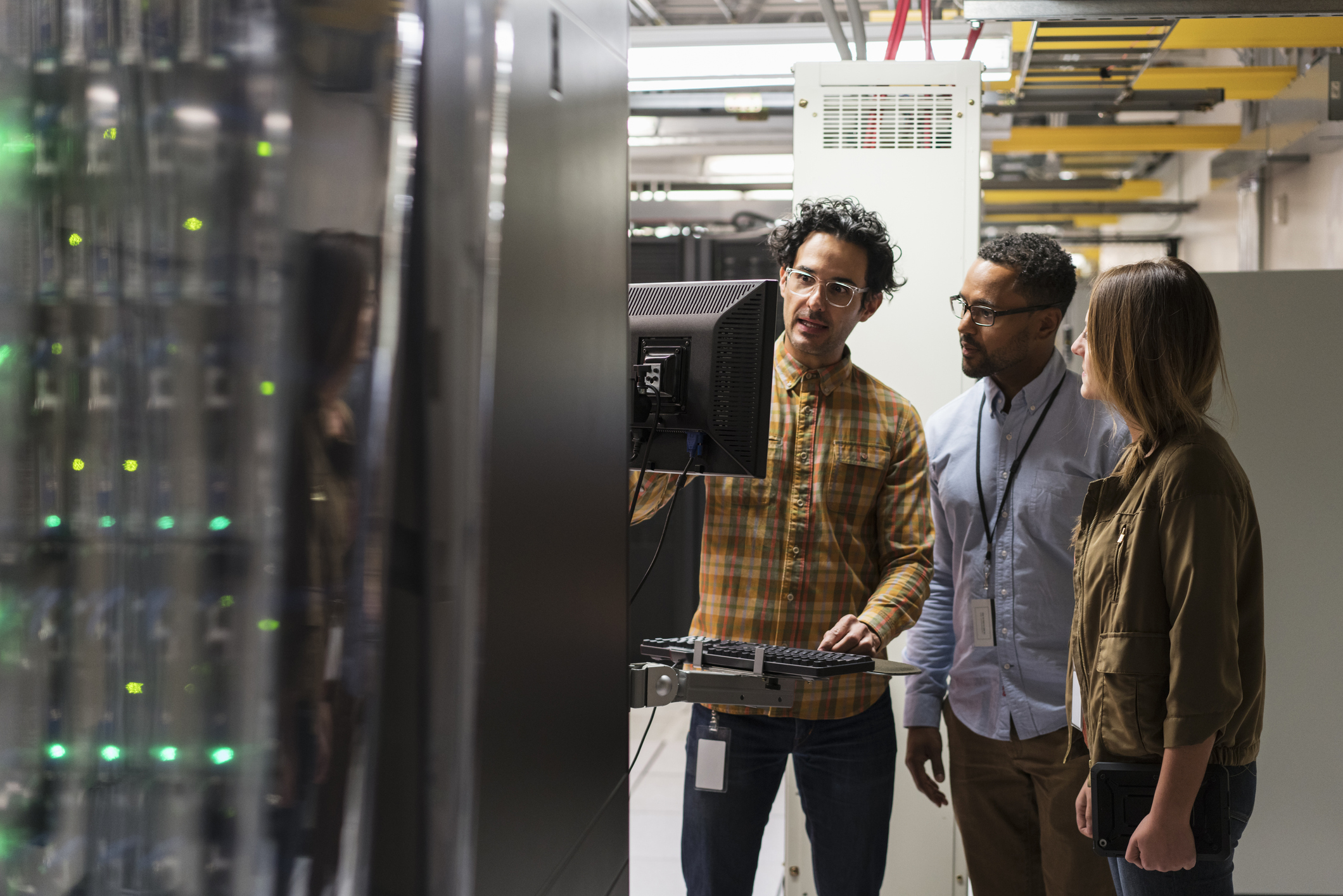 Three people working near a server.