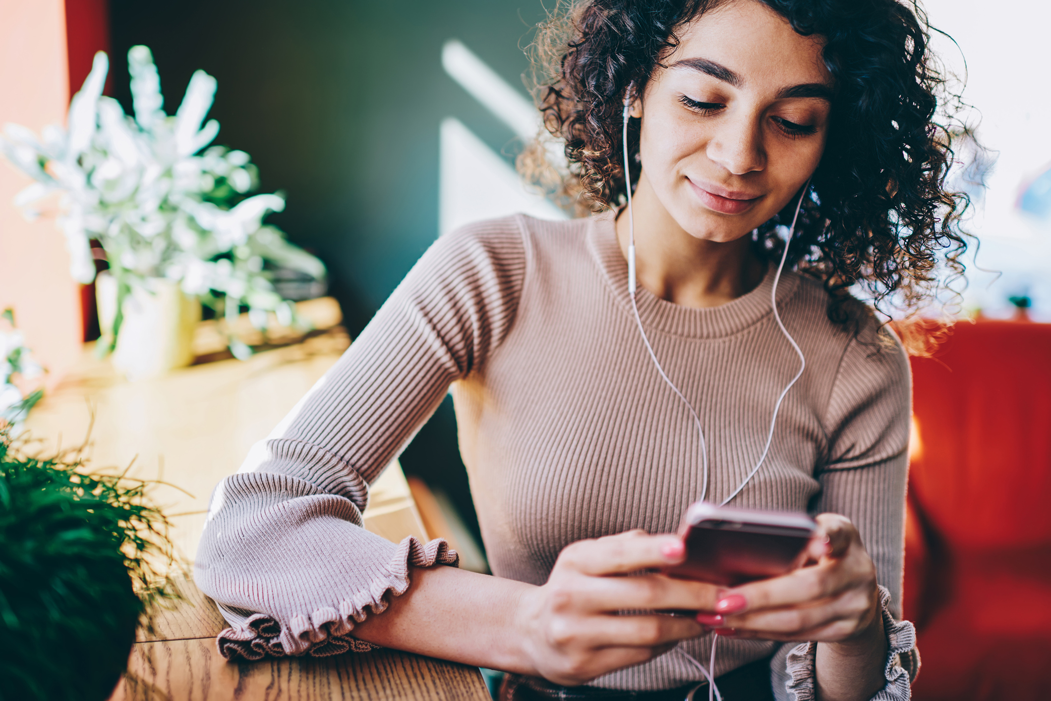 Person with headphones looking at a smartphone.