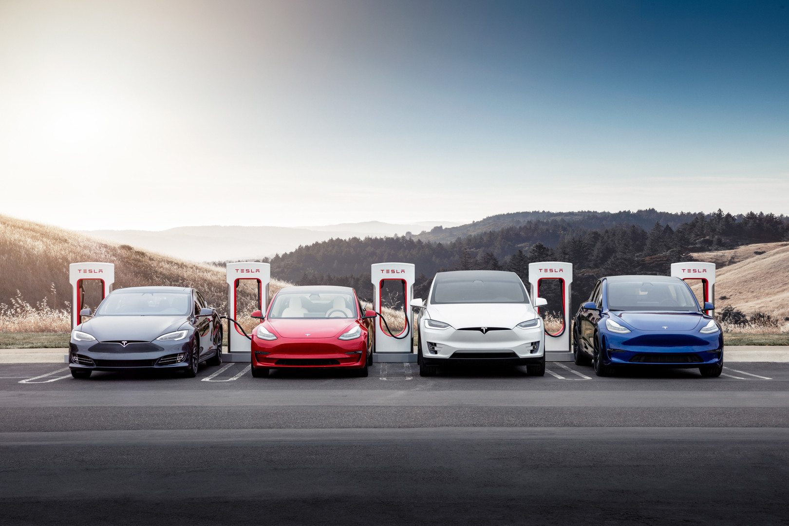 A Tesla Model S, Model 3, Model X and Model Y at a Supercharger station.