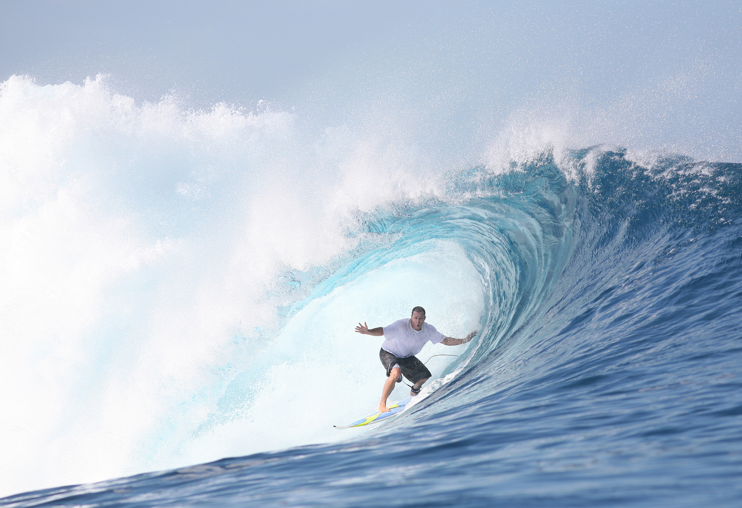 Surfer in the middle of a huge, breaking wave.