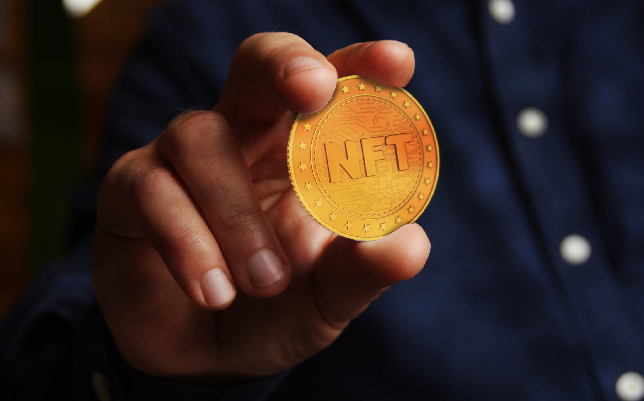 Hand holding an NFT coin.