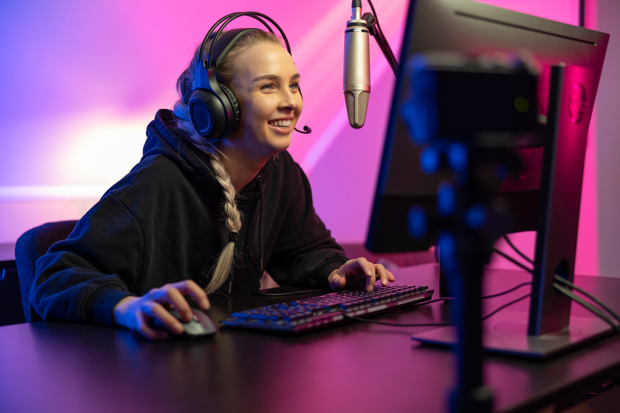 A gamer smiling at her gaming PC's screen.