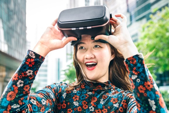 A person taking off a virtual reality headset.