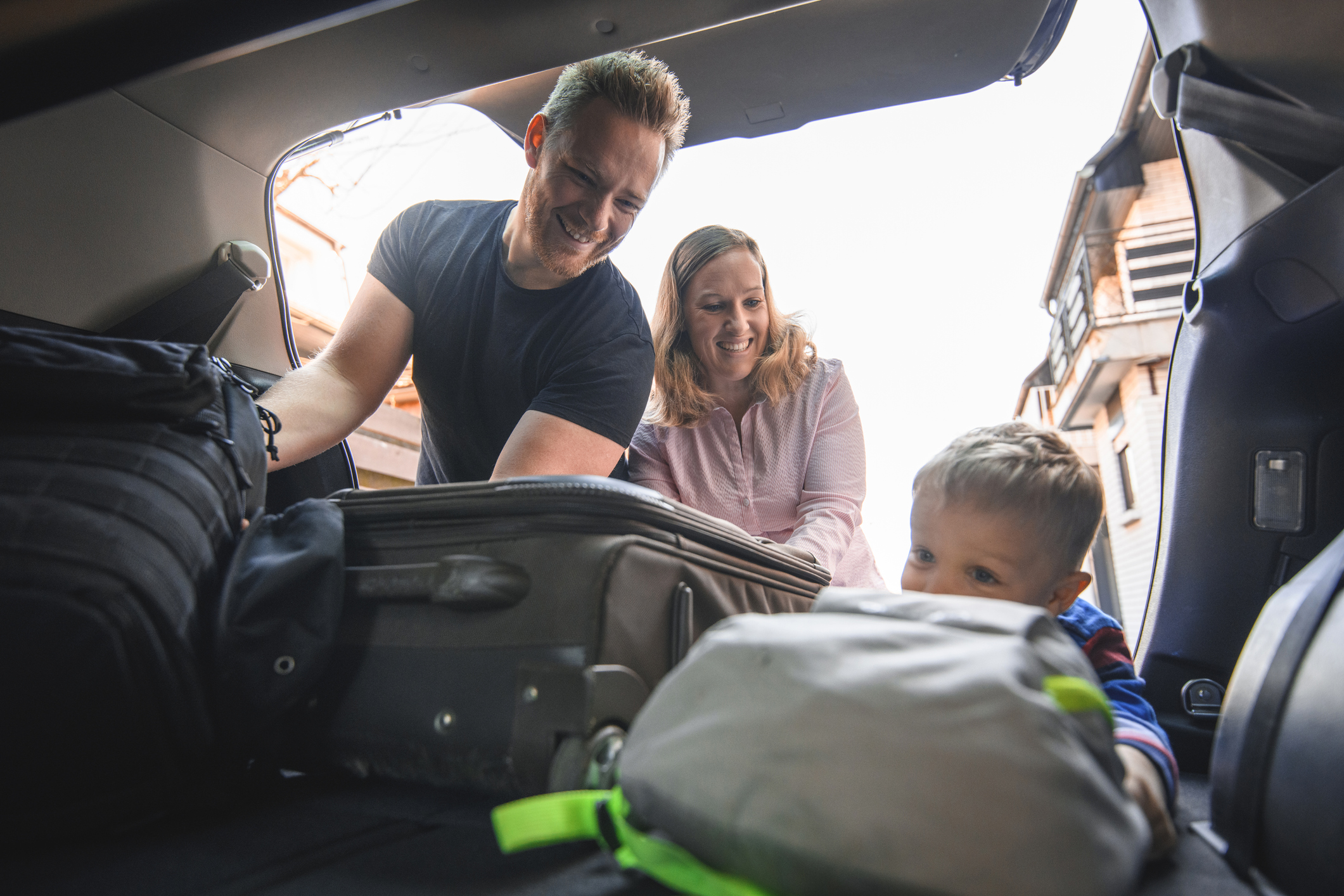 Family loading luggage into a vehicle.