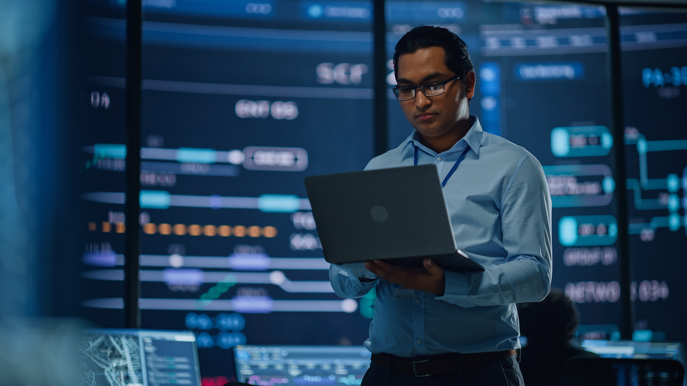 Software engineer with laptop in data center.
