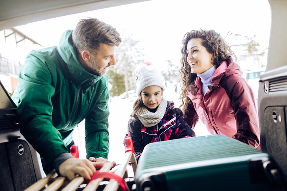 A family unloading luggage from a car.